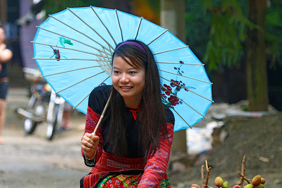 Junge Vietnamesin mit traditionellem Schirm
